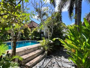 a swimming pool in the middle of a garden at Santai Retreat in Kuta Lombok