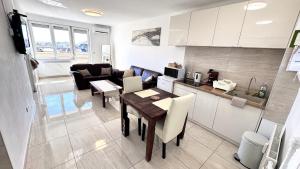 a kitchen and living room with a table and a couch at Rest House Apartman in Nyíregyháza