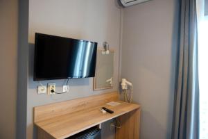 a flat screen tv on the wall of a room at Electra Hotel Piraeus in Piraeus