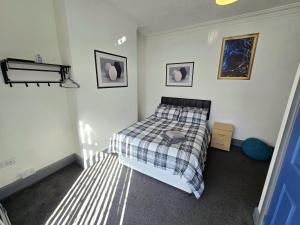 a bedroom with a bed and two pictures on the wall at Church Views in Burnley
