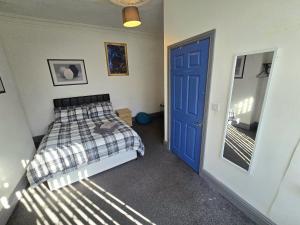 a bedroom with a bed and a blue door at Church Views in Burnley