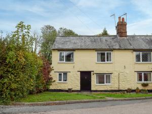 a yellow house on the side of a street at Richmond Cottage in Ashby Saint Ledgers