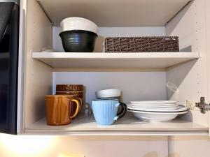 a pantry with plates and cups and bowls at Mori de house in kobe 302 in Kobe +26 photos