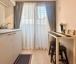 a small kitchen with a desk and a window at Mori de house in kobe 302 in Kobe