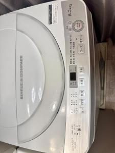 a white remote control sitting on top of a appliance at Mori de house in kobe 302 in Kobe