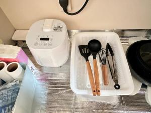 a plastic container with utensils sitting on a table at Mori de house in kobe 302 in Kobe
