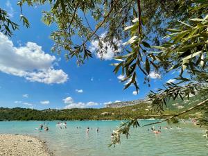 a group of people in the water at a beach at La Petite Maison in Puimoisson