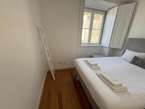 a bedroom with a bed with a ladder on the wall at Alfama Premium in Lisbon