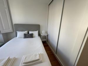a small bedroom with a white bed and a side table at Alfama Premium in Lisbon