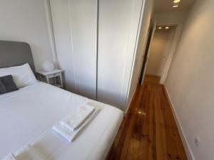 a bedroom with a white bed and a wooden floor at Alfama Premium in Lisbon