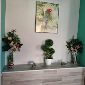 a table with flowers and a picture of a bird at B&B Luxury Suite Le Gladiaroom in Santa Maria Capua Vetere