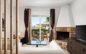 a living room with a couch and a fireplace at Megusta Apartments Selianitika - Poolside Escape in Selianitika