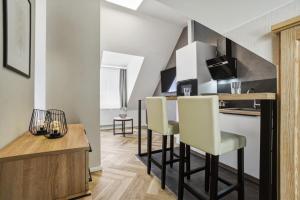 a kitchen and dining room with a bar with white chairs at Altstadt Pension Vlotho in Vlotho