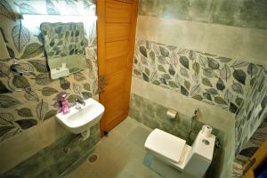 a bathroom with a sink and a toilet at Mountainshack Riverside Stay & Cafe in Kulu +29 photos