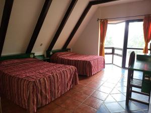 a bedroom with two beds and a balcony at Turinjandi in Zirahuén