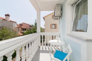 a white balcony with a white table and chairs at Guest House Jadro in Rovinj
