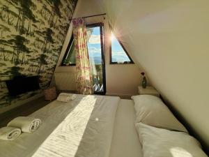 a large bed in a room with a window at Cabana Doinița in Borşa +25 photos