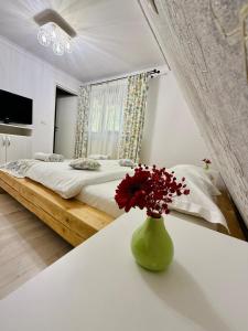 a bedroom with a bed and a vase with flowers on a table at Cabana Doinița in Borşa