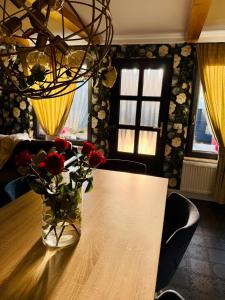 a vase of flowers sitting on a table with a vase of roses at Cabana Doinița in Borşa