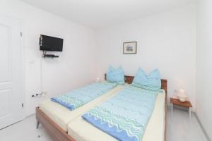 a bedroom with two beds with blue pillows at Guest House Jadro in Rovinj