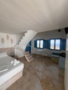 a bedroom with a white bed and a staircase at Villa Aigli in Anafi +102 photos