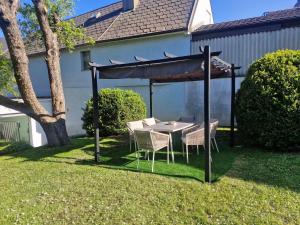 a table and chairs under a gazebo in a yard at Dreimäderlhof Ferienhaus in Karlstetten