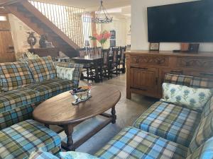 a living room with couches and a table and a television at La Maison du Parc in Saint-Vite