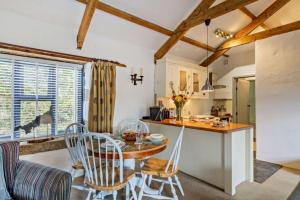 a kitchen and dining room with a table and chairs at Cobble Cottage in Cardinham
