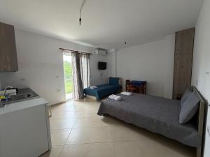 a bedroom with a bed and a couch and a kitchen at Villa Earta & Leo Ksamil in Ksamil