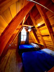 a attic room with two beds and a window at Glamping MORET Cabaña Alpina M2 in Los Lirios
