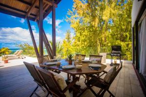 a wooden table and chairs on a patio at Beach Penthouse BELMARE in Belle Mare