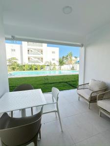 a patio with tables and chairs and a view of a pool at Mananero Group Residence in Cabarete