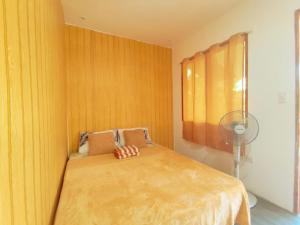 a bedroom with a bed with a wooden wall at Gregorio's Inn in San Vicente