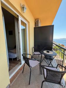 a balcony with chairs and a table with a view of the ocean at Apartments New Charming in Senj