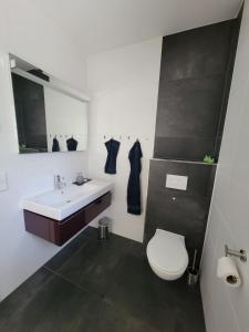 a bathroom with a white toilet and a sink at Heideberg Appartement in Zeuthen +17 photos