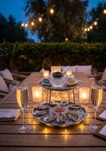 a table with a plate of food and glasses of wine at La Vecchia Fonte Boutique Hotel in Palau