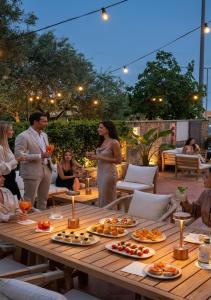 a group of people standing around a table with food at La Vecchia Fonte Boutique Hotel in Palau +56 photos
