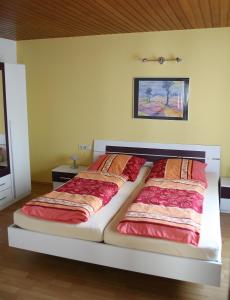 1 dormitorio con 1 cama grande con sábanas rojas en Ferienwohnung Neuber, en Bad Kissingen