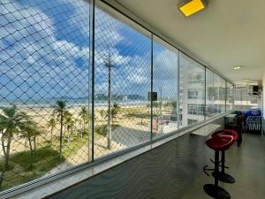 an office with a view of the beach through windows at Verdadeiro pé na areia TOP in Santos