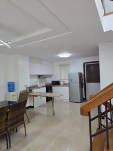 a kitchen with a table and a refrigerator at 3BR Courtyard Townhouse with 2 Parking at Canyon Woods in Lemery +6 photos