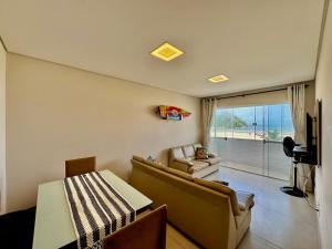 a living room with a couch and a table at Verdadeiro pé na areia TOP in Santos