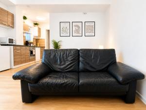 ein schwarzes Ledersofa im Wohnzimmer in der Unterkunft Airport Messe Hotel in Düsseldorf