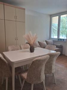 a dining room with a white table and chairs at STRUNA in Ohrid