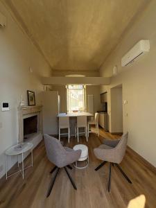 a living room with a table and chairs and a fireplace at Dimora del Loggiato in Acqui Terme