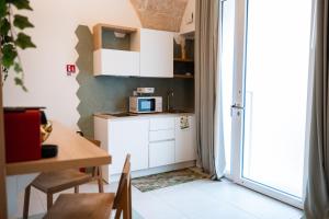 a small kitchen with a table and a microwave at Casa Gentile in Conversano +10 photos
