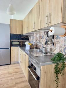 a kitchen with wooden cabinets and a stainless steel refrigerator at NextGen Casa Rossy in Antigua