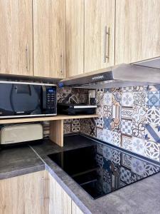 a kitchen with a microwave and a stove top oven at NextGen Casa Rossy in Antigua +25 photos