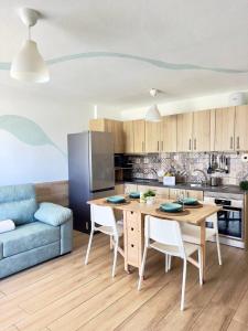 a kitchen with a table and a blue couch at NextGen Casa Rossy in Antigua