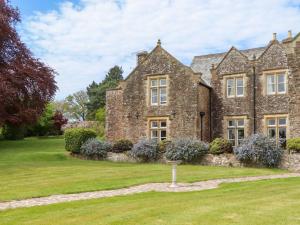 an old stone house with a garden in front of it at Dowrich West Wing Apartment in Crediton