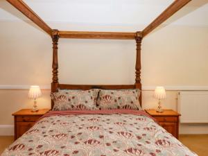 a bedroom with a bed with two lamps on tables at Dowrich West Wing Apartment in Crediton